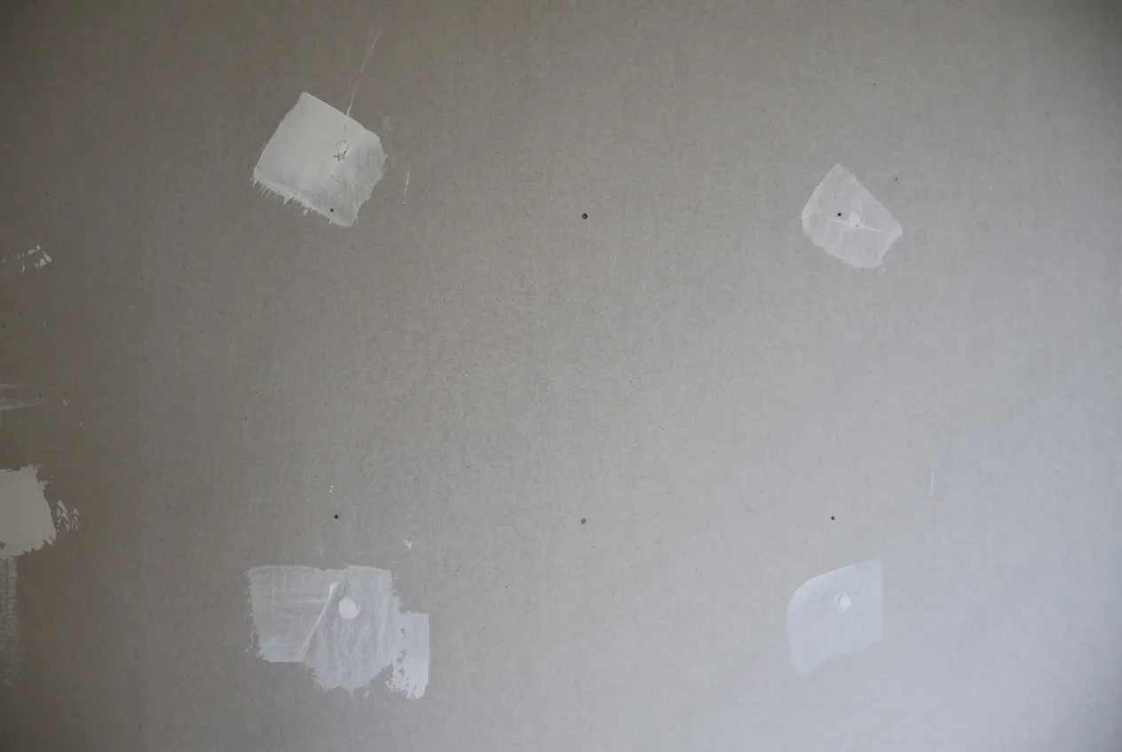 A wall with patched areas ready for preparation