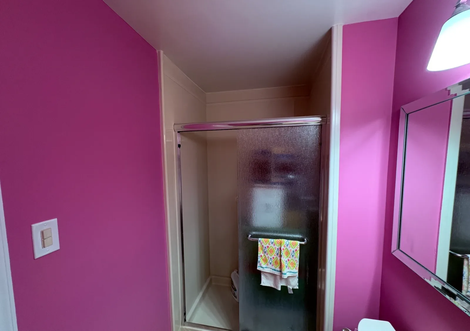 Bathroom with magenta walls, white trim, and a glass shower enclosure